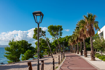 Idyllic seaside promenade in touristic coastal town Makarska, Split-Dalmatia, Croatia, Europe. Walkway along coastline of Makarska Riviera in Adriatic Mediterranean Sea. Tourist destination in summer © Chris