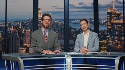 Friendly anchors smiling evening television channel closeup. Newsreaders talking