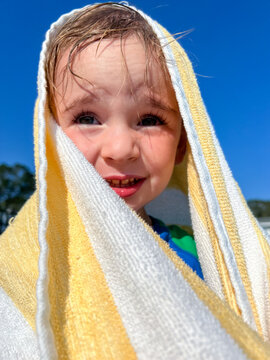 Child with Towel Wrapped Around his Head After Swimming at the Pool