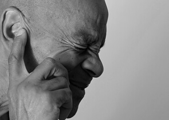 deaf man suffering from deafness and hearing loss on grey background with people stock photo	