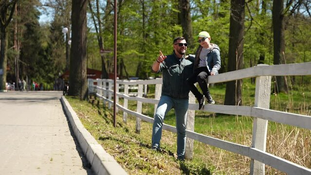 Father and Son Enjoying a Sunny Day at the Park. A joyful stroll with dad in the park. Concept Family Bonding