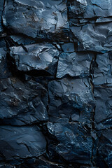 A close up of a grey bedrock wall with a pattern of dark blue rocks jutting out, resembling an outcrop. The darkness of the wall contrasts with the electric blue color of the rocks