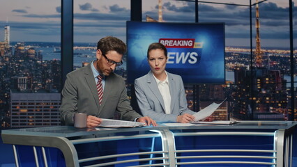 Presenters lighting breaking news in late tv studio closeup. Anchors discussing