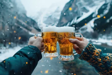 Foto op Canvas Two people are holding up two glasses of beer, toasting to a good time. The scene is set in a snowy mountain setting, with mountains in the background. Oktoberfest Concept © Nico