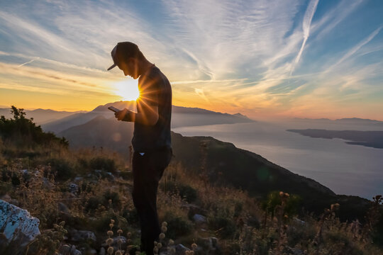Hiker man with scenic sunrise view from top of mount Kula near Omis, Dinara mountains, Split-Dalmatia, Croatia, Europe. Coastline of Makarska Riviera, Adriatic Sea. Balkans in summer. Biokovo mountain - Powered by Adobe