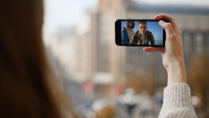 Happy friends waving smartphone on trip. Closeup hand hold mobile phone at city