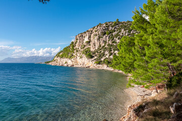 Fototapeta na wymiar Scenic view of idyllic hiking trail along majestic cliffs between coastal villages Krvavica and Makarska, Dalmatia, South Croatia, Europe. Majestic Makarska Riviera, Adriatic Mediterranean Sea. Summer