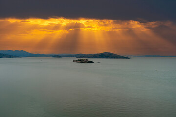 aerial shot of Alcatraz Island with mountain ranges and vast miles of blue ocean water with...