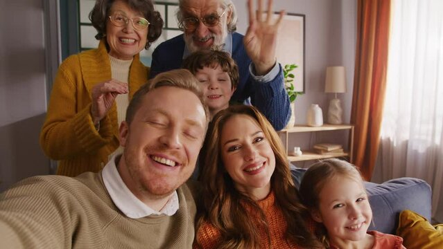 Big caucasian family waving hi to camera during video call