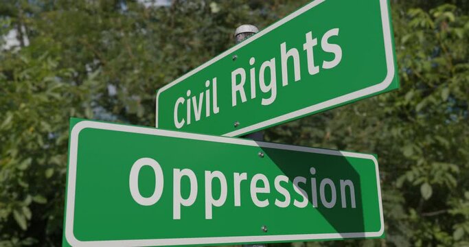 Pan of Civil Rights, Oppression 2 Way Green Road Sign Along The Road.
