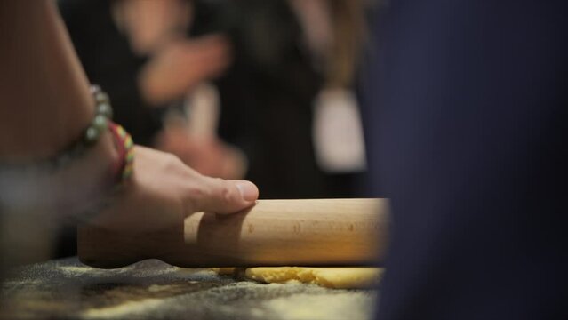 Cook working his dough with a rolling pin