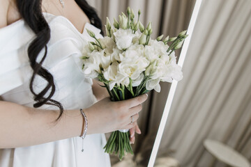 Bride's delicate grasp on elegant white bouquet