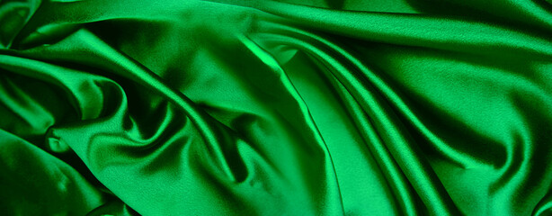 Close-up of rippled green satin silk fabric