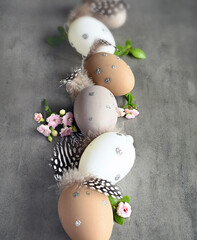 Collection of stylish colors eggs with flowers for Easter celebration on grey background.