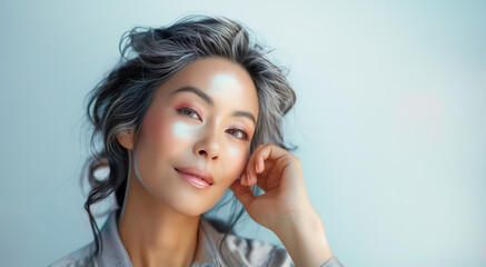 Beautiful Asian woman face portrait with young smooth looking skin. Asian woman portrait with hand on cheek for healthy skin advertising of skincare cosmetics - 759229430