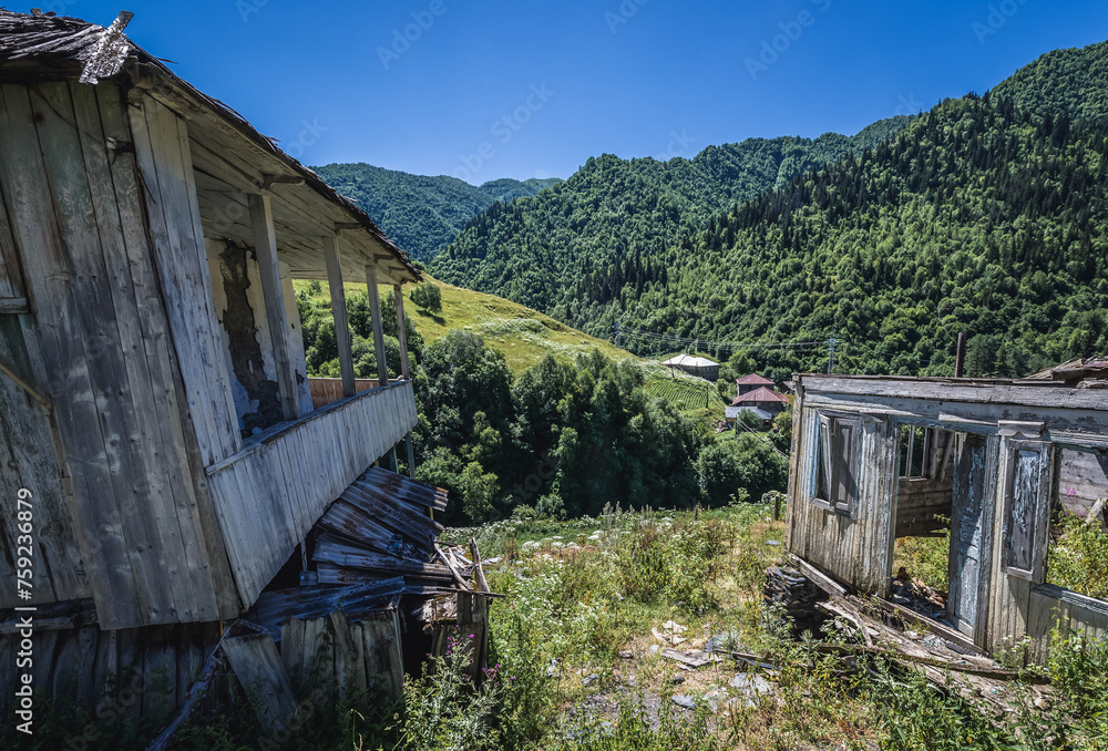 Poster Wooden houses in partly abandoned village on the road from Mestia to Ushguli in Svanetia region, Georgia