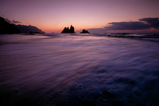 Soft twilight hues caress Playa de Benijo, casting a peaceful ambiance over the sea stacks and tranquil waves