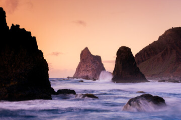 The sun dips below the horizon at Playa de Benijo, whispering goodnight with a warm palette against the silhouette of majestic sea stacks