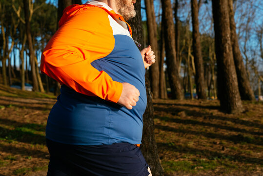 Overweight man running in park for exercise and health