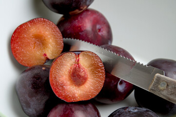 juicy red plums on white background