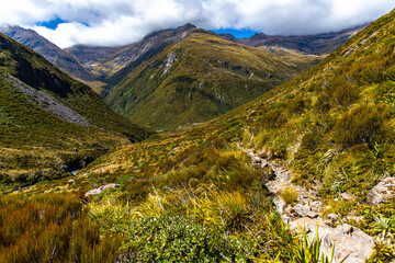 panorama of otira valley in arthur's pass national park, canterbury, new zealand south island; scenic valley with rushing river surrounded with mighty mountains