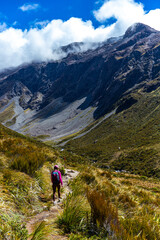 Obraz premium backpacker enjoys a scenic trail in otira valley, panorama of mountains in arthur's pass national park, canterbury, new zealand south island