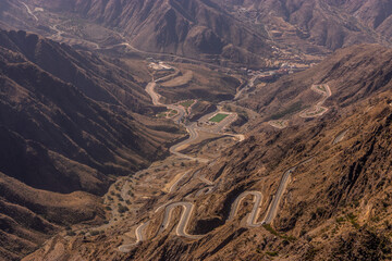 View of Al Souda mountains with a winding road near Abha, Saudi Arabia - obrazy, fototapety, plakaty