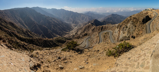 View of Wadi Hali in Al Souda mountains with a winding road near Abha, Saudi Arabia - obrazy, fototapety, plakaty