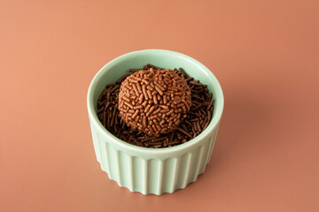 Chocolate truffle balls Brigadeiro brazilian candy and chocolate flakes front view green bowl