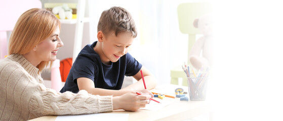 Female psychologist working with boy suffering from autistic disorder