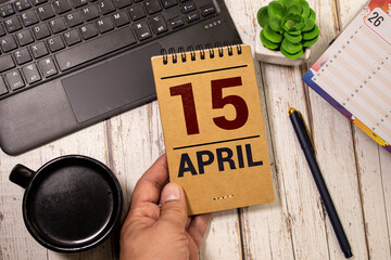 April 15th. Day 15 of month, calendar on wooden table and turquoise background. - obrazy, fototapety, plakaty