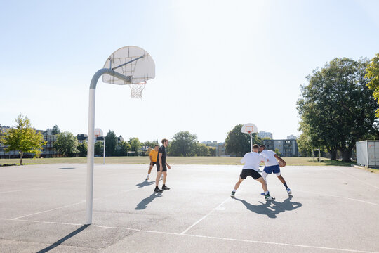 A group of friends playing basketball together outside.
