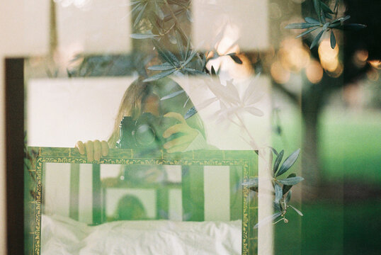 Anonymous woman and mirror frame over nature background