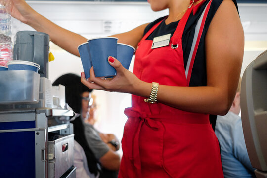 Flight attendant serving beverages during the flight