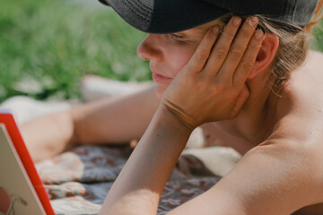 Young woman reading a book while relaxing on the lake