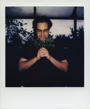 Polaroid of a Happy Man Holding and Sniffing a Mint Leaves