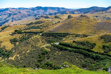 panorama of banks peninsula with winding road on a hill near akaroa harbour; canterbury, new...