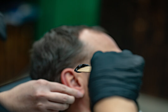 man having his beard cut and colored