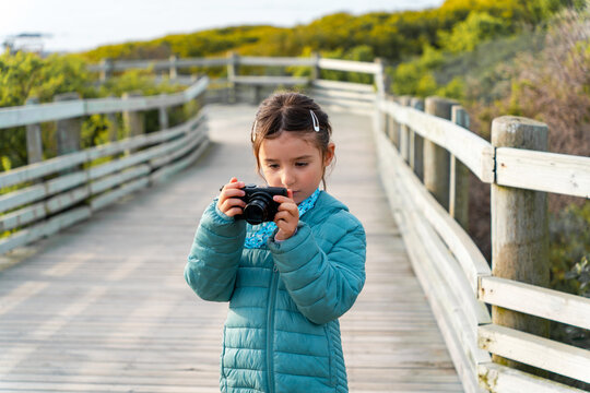 Curious Kid taking photos with camera outdoors.  UGC travel