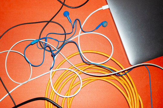 Silver laptop and colourful curve wires with hard direct flashlight