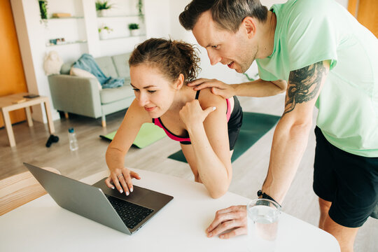 Couple in sportswear using laptop