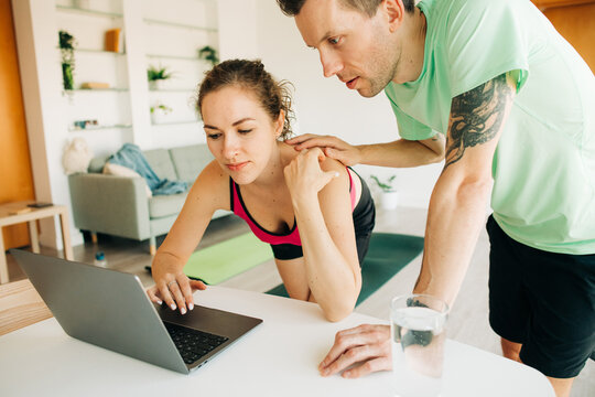 Couple in sportswear using laptop