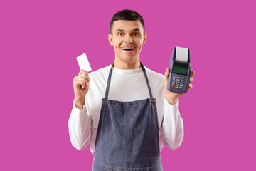 Male online store seller with credit card and payment terminal on purple background