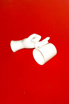 Porcelain hand holding a coffee cup with hard direct flashlight