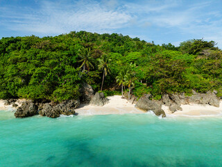 Rocks and white sand with ocean waves in Carabao Island. San Jose, Romblon. Philippines.