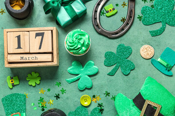Calendar with cupcake, gift box and decor for St. Patrick's Day on green grunge background