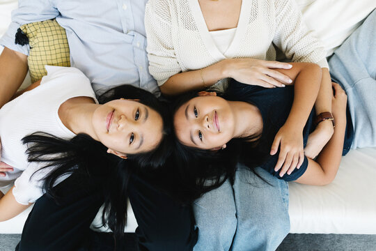 Two girls resting on parents' laps