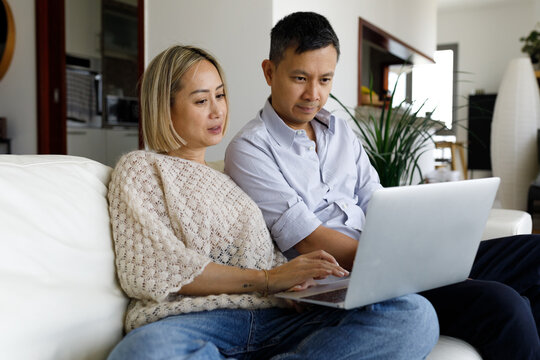 A couple sitting with a laptop at home