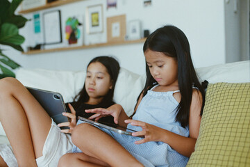 Two girls with  tablet computers at home