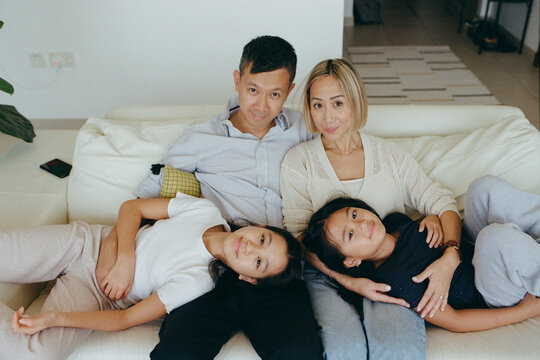 Family of four at home on a sofa 